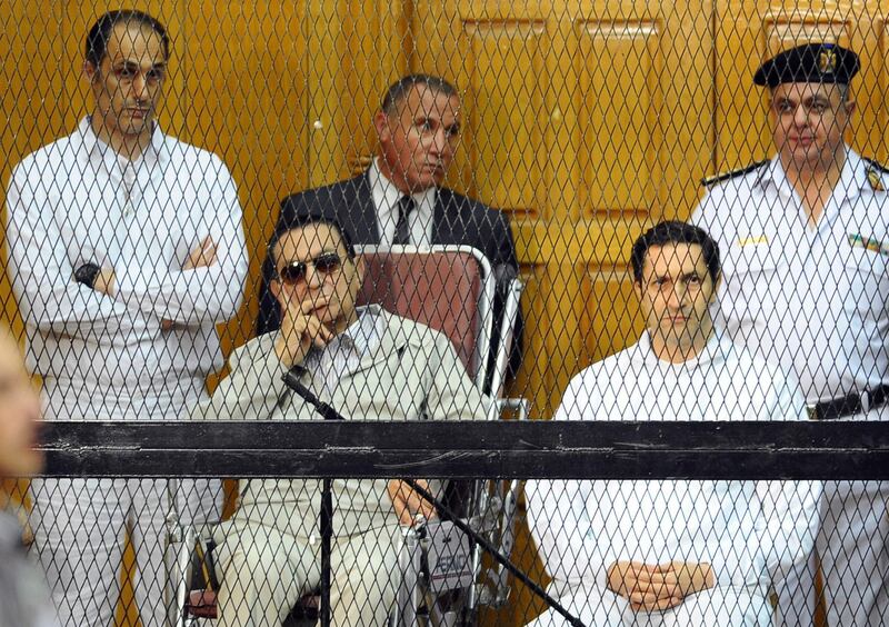 FILE - In this Sept. 14, 2013 file photo, former Egyptian President Hosni Mubarak, seated center left, and his two sons, Gamal Mubarak, left, and Alaa Mubarak attend a hearing in a courtroom in Cairo, Egypt.  Egyptian officials say police have detained the sons of former president Hosni Mubarak in connection with inside trading charges. They said the arrests were ordered Saturday, Sept. 15, 2018 by judge Ahmed Aboul-Fetouh before he adjourned the hearings to October 20. (AP Photo/Mohammed al-Law, File)