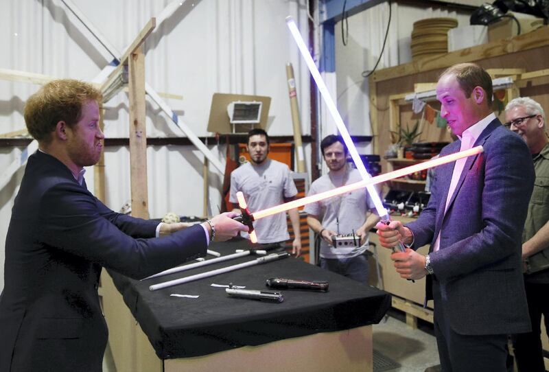 IVER HEATH, ENGLAND - APRIL 19: Prince Harry (L) and Prince William, Duke of Cambridge try out light sabres during a tour of the Star Wars sets at Pinewood studios on April 19, 2016  in Iver Heath, England. Prince William and Prince Harry are touring Pinewood studios to visit the production workshops and meet the creative teams working behind the scenes on the Star Wars films. (Photo by Adrian Dennis-WPA Pool/Getty IMages)