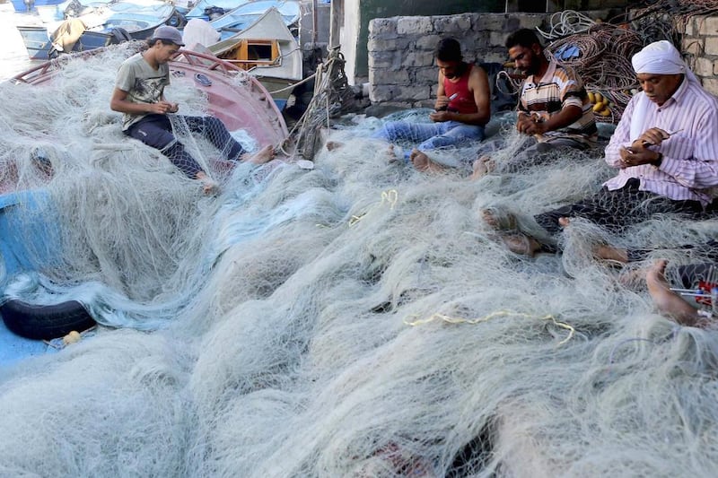 Men sew their nets in the fishermen’s village in El Max. Almost every day, the fishermen wake up before dawn and return home in the evening, earning just 10 Egyptian pounds. Amr Abdallah Dalsh / Reuters