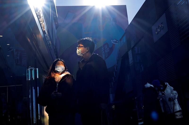 People wear masks as they walk in a shopping district, following an outbreak of the coronavirus disease (COVID-19) in Beijing, China. REUTERS