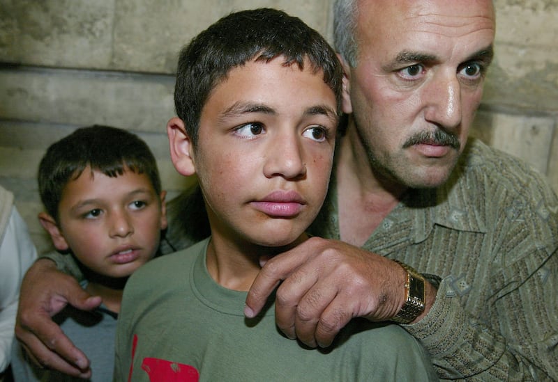 Arab, left, and  Sharaf, centre, Barghouti, sons of Marwan Barghouti, wait to enter an Israeli court on the opening day of their father's trial in September 2002 in Tel Aviv, Israel. Getty Images