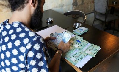 Moussa Yaakoub, a Lebanese business owner, counts his earnings. More than 80 per cent of the country's population lives below the poverty line. Reuters