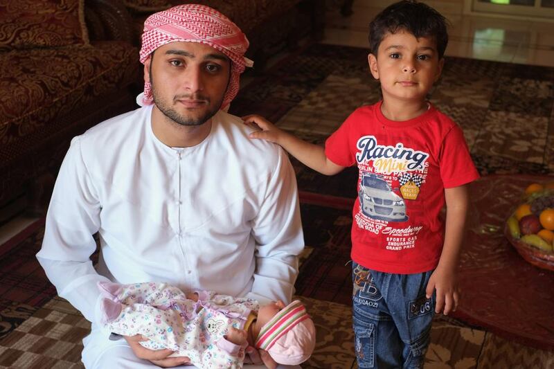 Ahmed Al Kaabi with his one-month-old daughter Marim and his son, Khalifa. Ahmed suffers from epilepsy and has been fired from every job because of his condition. Delores Johnson / The National