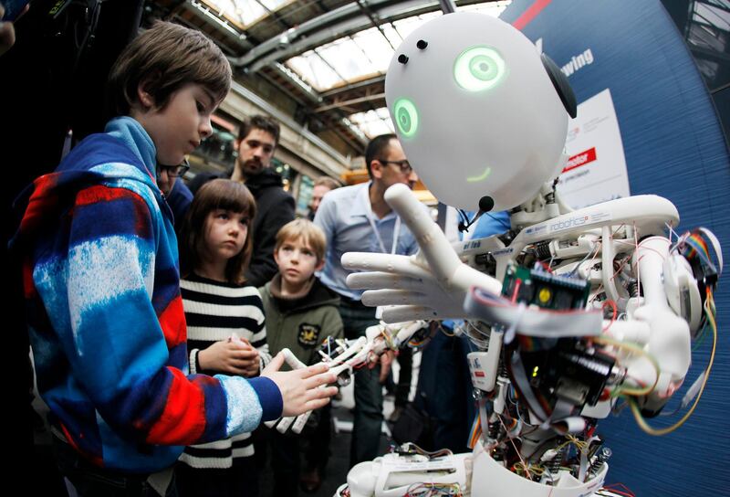 Children interact with the humanoid robot Roboy at the exhibition Robots on Tour in Zurich, March 9, 2013. A project team composed of scholars and industry representatives developed the prototype of the tendon driven humanoid robot Roboy within nine months.  Roboy was unveiled to the public today during the exhibition that is marking the 25th anniversary of the Artificial Intelligence Laboratory of the University of Zurich (AI Lab). Picture taken with fish-eye lens. REUTERS/Michael Buholzer (SWITZERLAND - Tags: SCIENCE TECHNOLOGY SOCIETY BUSINESS) - BM2E93916CJ01