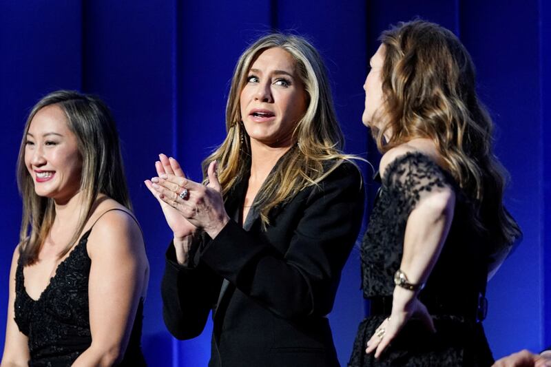 Actresses Jennifer Aniston, centre, and Drew Barrymore, right, react. Reuters