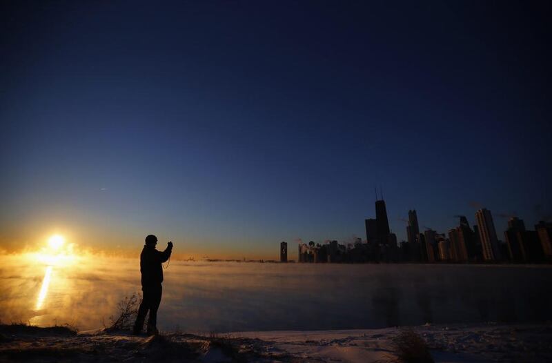 Fireman Joe Castello, taking a picture, is silhouetted against fog rising off Lake Michigan in Chicago, Illinois, on January 28, 2014. Chicago ­­— where it was ­–24C on Tuesday —and other parts of the upper Midwest in the United States were forecast to have a second consecutive day of subzero highs. Jeff Haynes / Reuters photo