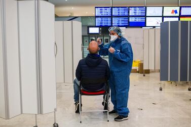 A health worker administers a Covid-19 swab test on an airline traveller at Charles de Gaulle airport. Bloomberg. 