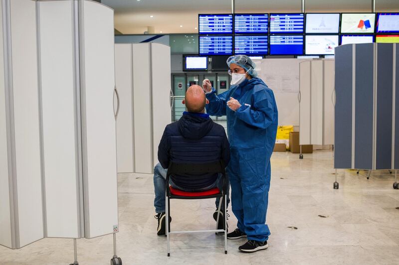 A health worker administers a Covid-19 swab test on an airline traveler at Charles de Gaulle airport, operated by Airport de Paris, in Roissy, France, on Tuesday, Oct. 6, 2020. The European Union’s battered aviation industry may soon get some relief from the confusingly wide range of travel curbs across the continent, as the bloc’s governments seek agreement on a common threshold for imposing restrictions. Photographer: Nathan Laine/Bloomberg