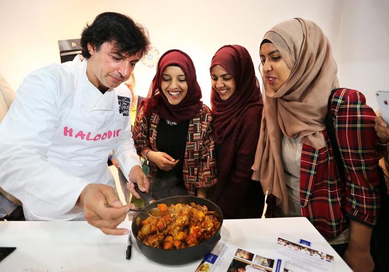 Jean Christophe Novelli gives a cookery demonstration to Sidra, Ghausia and Saania Hussain at the Halal Food Festival in London. Stephen Lock for The National


