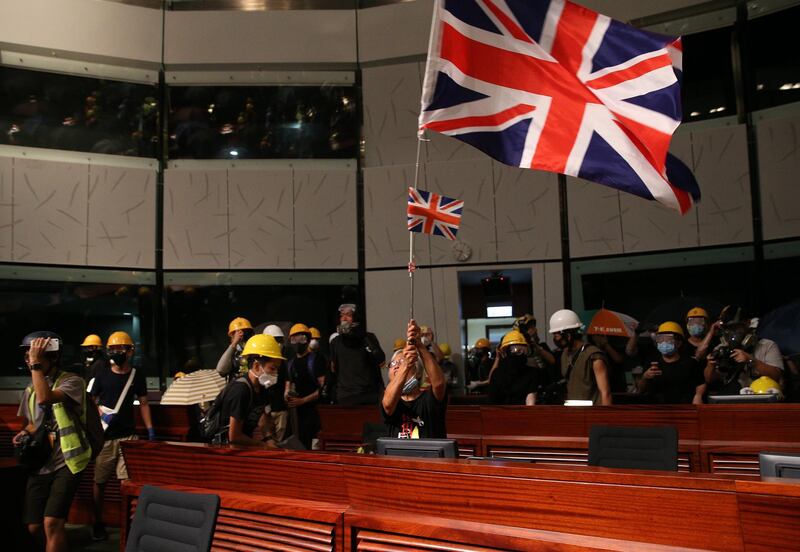 Protesters wave the British colonial flag after breaking into the main chamber of the Legislative Council building. EPA