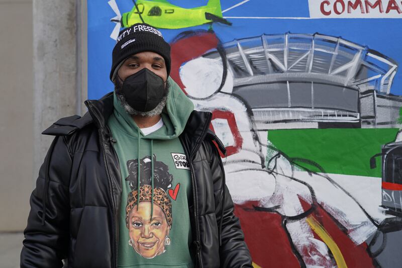 Demont Pinder poses next to a mural he painted showing the team's new name. Willy Lowry / The National.