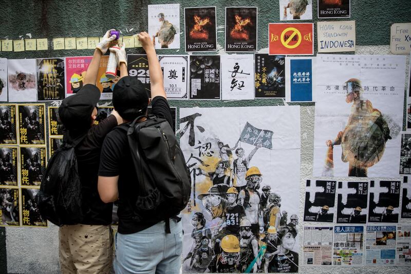 Pro-democracy protesters glue up posters and sticky notes to make a "Lennon Wall" before a rally to mark the fifth anniversary of the 2014 Umbrella Movement. Getty Images