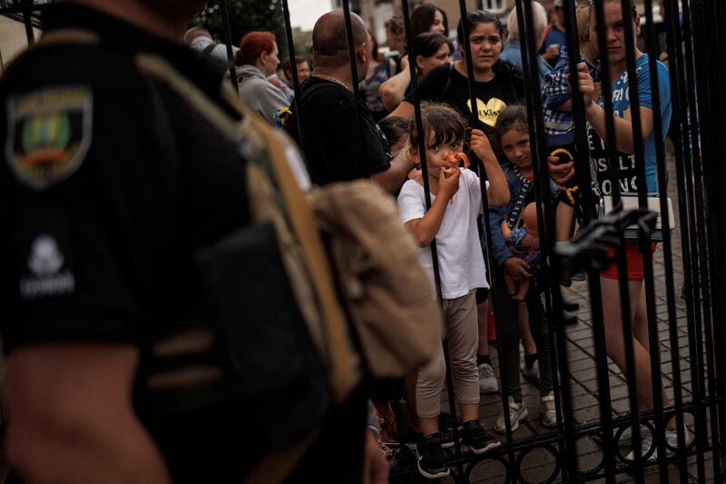 A girl holds a doll as people wait in Pokrovsk, to board a train to Dnipro and Lviv, during an evacuation effort from war-affected areas of eastern Ukraine. Reuters