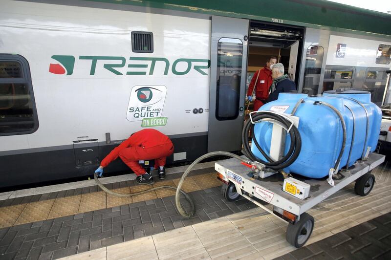 Cleaners sanitize a wagon on a regional train, at the Garibaldi train station in Milan, Italy, Friday, Feb. 28, 2020. Authorities are taking new measures to sanitize trains and public transportation after the COVID-19 virus outbreak. (AP Photo/Luca Bruno)