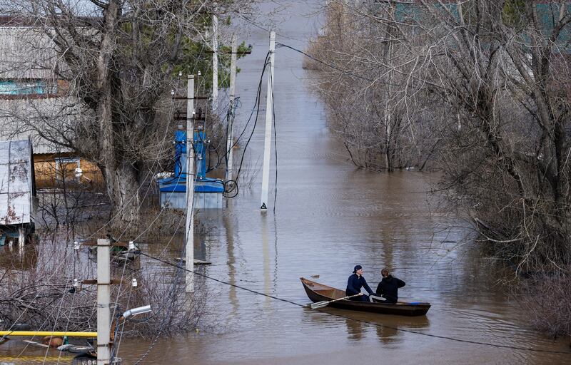 People row a boat through a flooded residential area in Orenburg, south-west Russia. Reuters