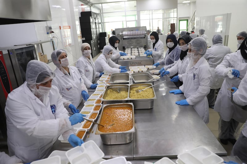 Volunteers clothed in personal protection equipment prepare meals throughout the day for iftar in Ankara, Turkey.  AFP