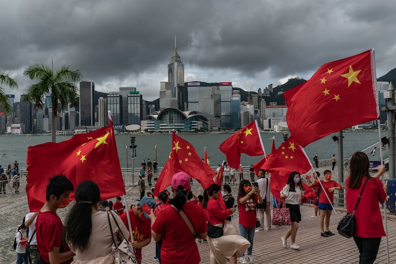 People wave Chinese national flags at Victoria Harbour promenade in Hong Kong on July 1, 2022. Getty Images