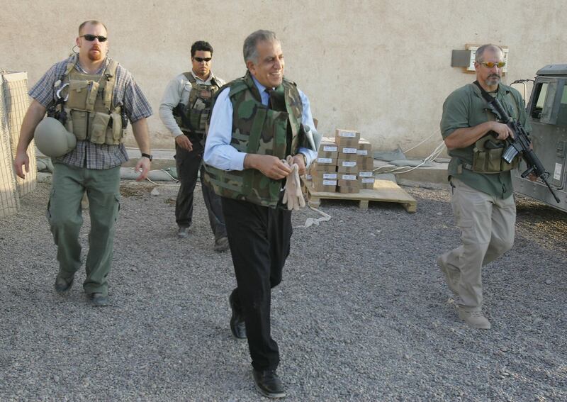 (FILES) In this file photo taken on October 15, 2005, US Ambassador to Iraq Zalmay Khalilzad, wearing a flack jacket and surrounded by bodyguards from the US security firm Blackwater, leaves the Civil and Military Operation Center (CMOC) in Fallujah. Iraqis on December 23, 2020 were outraged, heartbroken but not surprised to hear of a US presidential pardon for four American security guards convicted of killing Iraqi civilians in Baghdad in 2007. The Blackwater team, contracted to provide security for US diplomats in Iraq following the American-led invasion in 2003, claimed they were responding to insurgent fire. The bloody episode left at least 14 Iraqi civilians dead and 17 wounded.
 / AFP / Patrick BAZ
