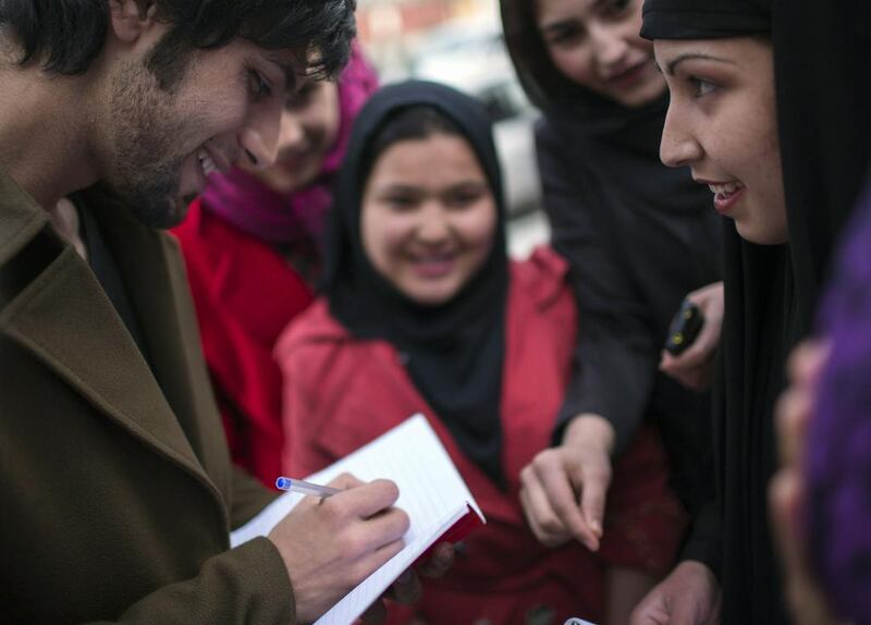 Afghan pop singer Arash Barez signs an autograph a fan after his concert to mark International Women’s Day in the Kabul-Dubai wedding hall.