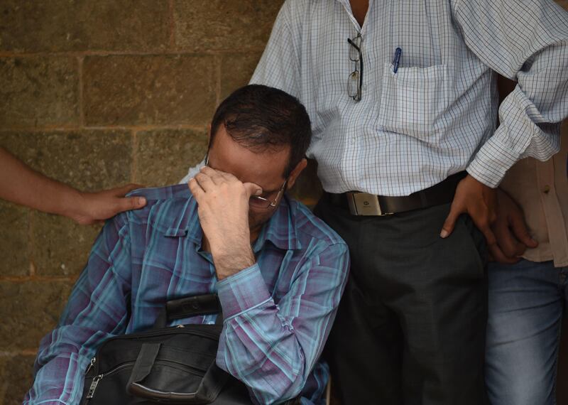 Indian relatives of victims injured at a stampede on a railway bridge react as they wait at a hospital in Mumbai. Punit Paranjpe / AFP