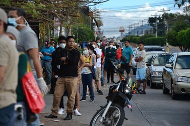 People queue outside a supermarket during a break of the curfew imposed by the government in Honduras. AFP