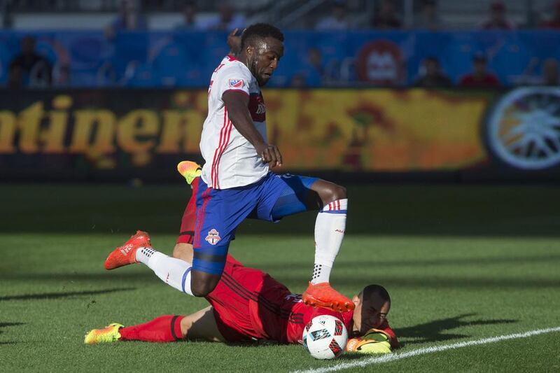 Toronto FC’s Jozy Altidore, left, moves the ball past New York Red Bulls goalkeeper Luis Robles before shooting wide during first half of a Major League Soccer match in Toronto. Chris Young / The Canadian Press via AP