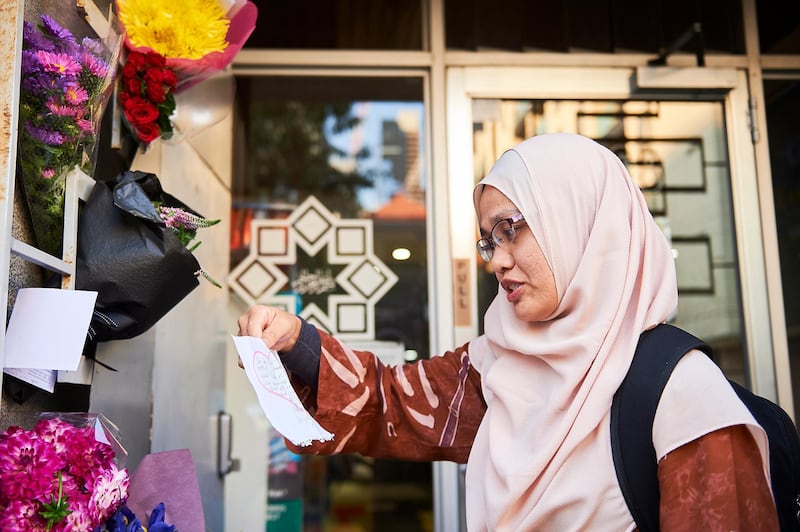 MELBOURNE, AUSTRALIA - MARCH 16: Syima Mansor reads a note after prayer, as flowers and cards are left outside the mosque at the Islamic Council of Victoria on March 16, 2019 in Melbourne, Australia. At least 49 people are confirmed dead, with more than 40 people injured following attacks on two mosques in Christchurch, New Zealand on Friday afternoon. 41 of the victims were killed at Al Noor mosque on Deans Avenue and seven died at Linwood mosque. Another victim died later in Christchurch hospital. Three people are in custody over the mass shootings. One man has been charged with murder. (Photo by Jaimi Chisholm/Getty Images)