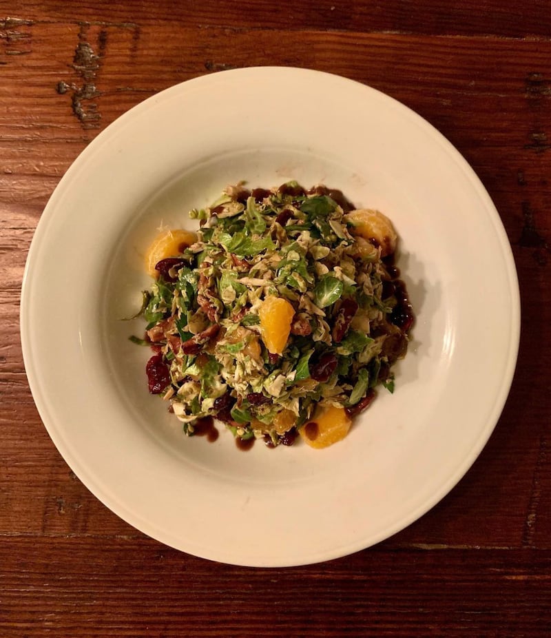 Shaved Brussels sprout salad tossed with dried cherries and cranberries, clementine, toasted pecans, ricotta cheese and a house-made balsamic vinaigrette dressing.