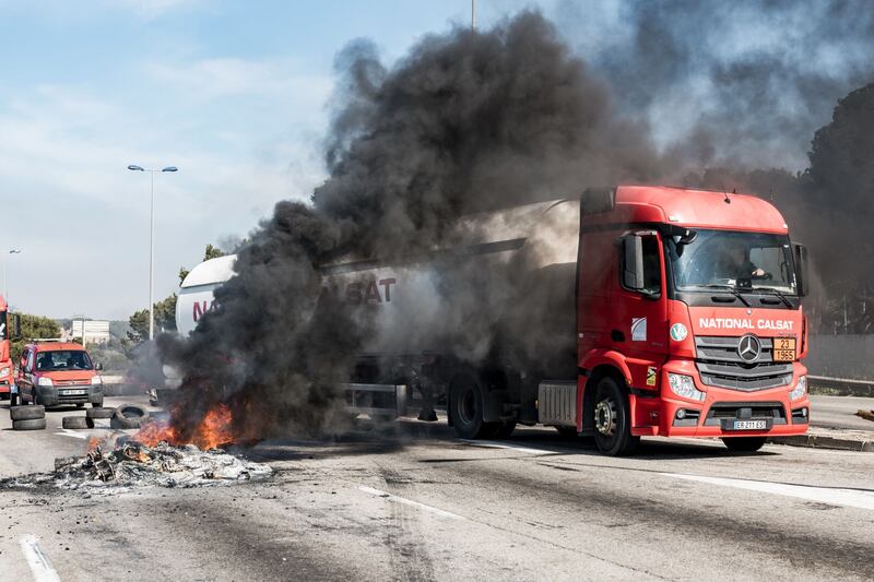 A lorry driver navigates through a fire lit by striking members of the General Confederation of Labour union in Fos-sur-Mer. Bloomberg
