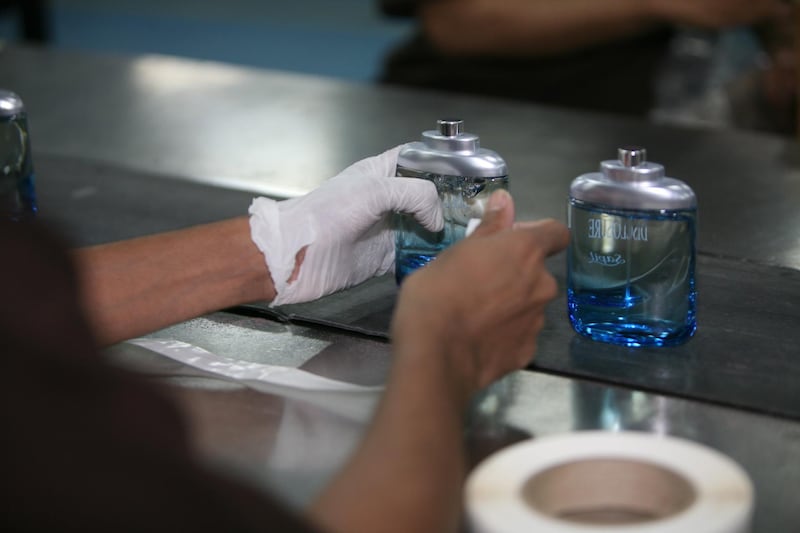 SHARJAH, UNITED ARAB EMIRATES - June 1:  Workers on an assembly line producing bottles of perfume at the Swiss Arabian Perfumes Group factory in Sharjah on June 1, 2008. Before the perfume is ready for the production line it goes through a mixing process and to the gas chromatography lab where it is tested for its quality of ingredients. On the production line, workers fill bottles with the perfume which they call ÒjuiceÓ and then the bottles are sealed, polished and packaged. The company produces such brands as Sapil, Swiss Arabian, Shirley May and Alta Moda. (Randi Sokoloff / The National) *** Local Caption ***  RS002-SwissArabia.jpgRS002-SwissArabia.jpg