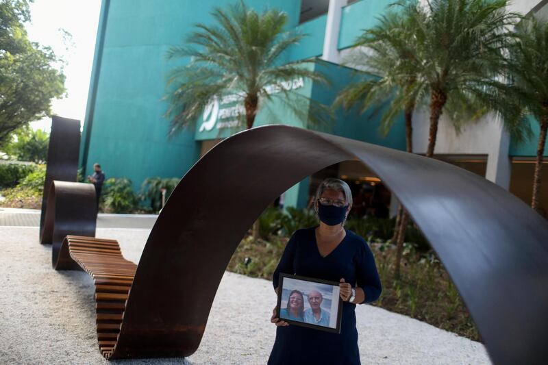 Giselle Matuk Diniz Peixoto holds a photo where she is with her father Geraldo Diniz Gonsalves, who died from the coronavirus disease (COVID-19), next to a memorial for covid victims called the Infinity Memorial at the Penitencia cemetery in Rio de Janeiro, Brazil September 24, 2020. Picture taken September 24, 2020. REUTERS/Pilar Olivares