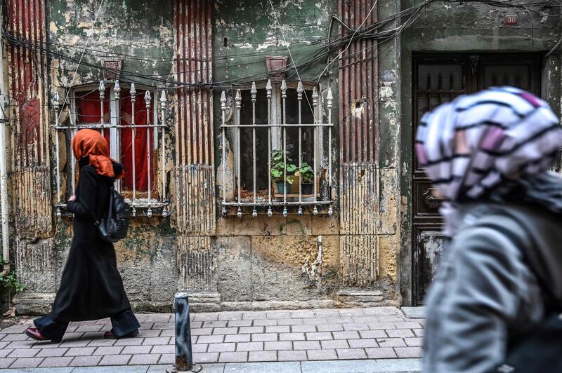 Women walk past an abandoned building of Balat district, Istanbul,  AFP