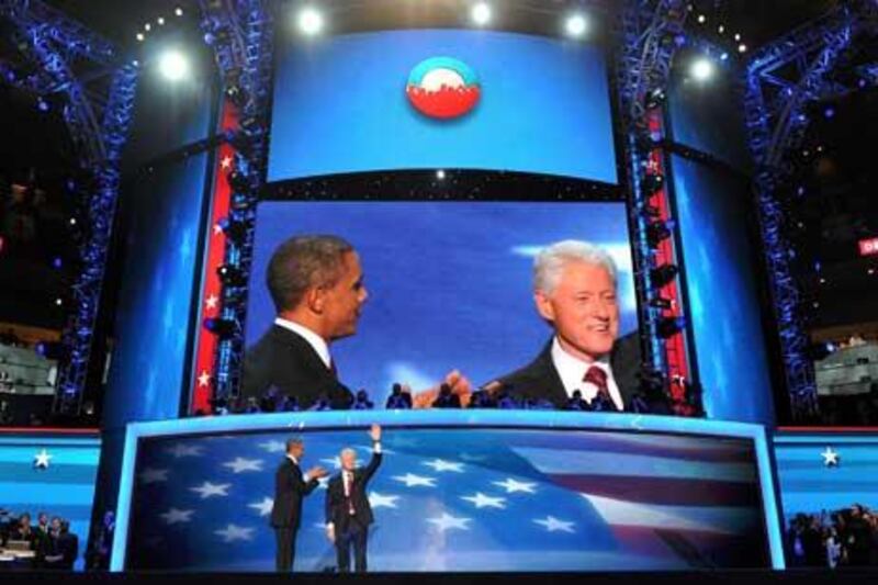 The 42nd President of the United States Bill Clinton and the 44th President of the United States Barack Obama acknowledge the audience.