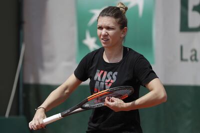 Romania's Simona Halep adjusts the strings of her racquet during a training session in Paris on May 24, 2018, ahead of The Roland Garros 2018 French Open tennis tournament. / AFP / Thomas SAMSON

