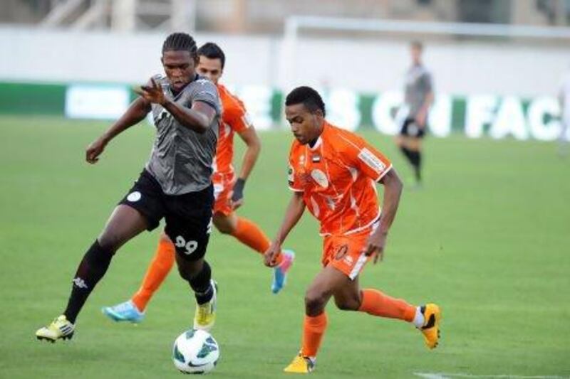 Al Dhafra's Makhete Diop, in black and grey, showed enough pace against the Ajman defenders yesterday. Mutawakil Mubarak / Al Ittihad