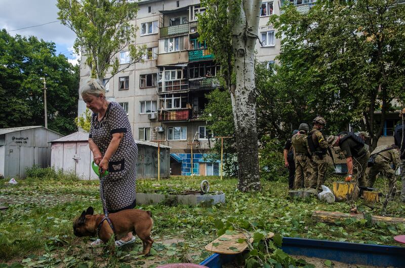 A woman walks her dog in front of a block of flats hit by shelling in Kramatorsk, Donetsk region, eastern Ukraine. EPA