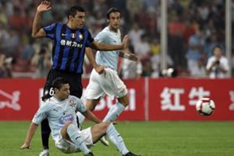 Inter Milan's new defensive signing from Bayern Munich Lucio, left, challenges Lazio's Mauro Zarate, bottom, during the Rome side's 2-1 Italian Super Cup victory at the Bird's Nest stadium in Beijing yesterday.