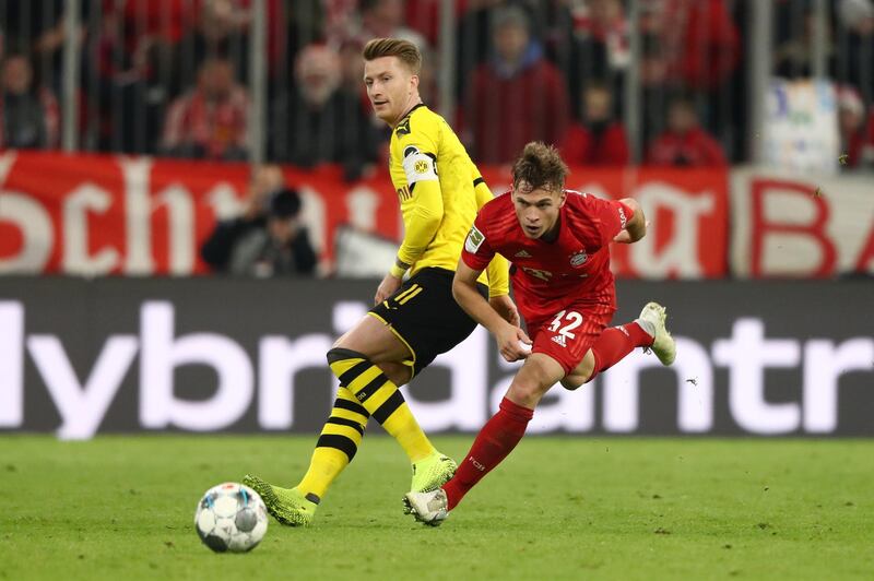Bayern full-back Joshua Kimmichevades the challenge of Dortmund forward Marco Reus. Getty Images