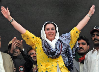 Former Pakistani prime minister Benazir Bhutto waves to the crowd during an election campaign meeting in Larkana, 23 December 2007. After one of the bloodiest attacks in Pakistan in memory, opponents of President Pervez Musharraf hit the campaign trail 23 December with just two weeks to go before pivotal elections for parliament.  AFP PHOTO/Asif HASSAN (Photo by ASIF HASSAN / AFP)
