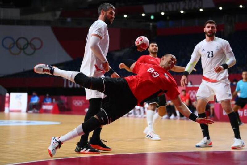 Egypt's pivot Mohamed Mamdouh Shebib shoots past France's pivot Luka Karabatic and Ludovic Fabregas.