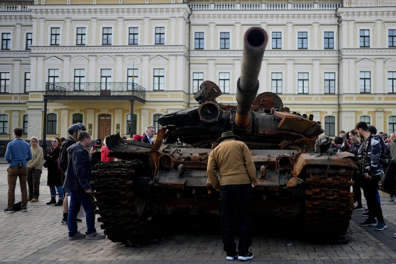 A man looks at a destroyed Russian tank placed as a symbol of war, in central Kyiv. AP
