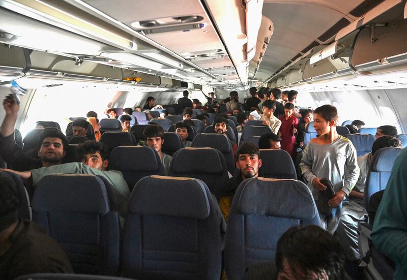 These Afghan passengers made it. They sit inside a plane and wait to leave Kabul. AFP