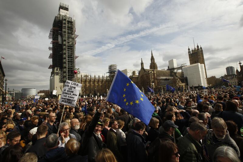Demonstrators wave large European Union flags as they stand in Parliament Square. Bloomberg