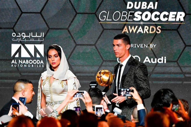Juventus' Portuguese forward Cristiano Ronaldo (R), holding his "Best Player of the Year 2018 Award" poses with his companion Georgina Rodriguez during the 10th edition of the Dubai Globe Soccer Awards. AFP