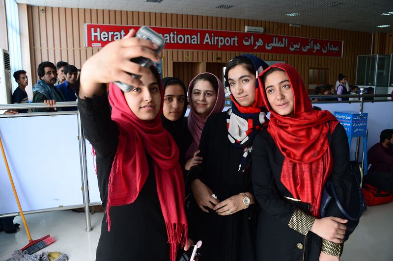 Afghan teenagers from the Afghanistan Robotic House take pictures with a mobile phone at Herat International Airport on July 13, 2017, before embarking for the United States.
A team of Afghan girls who had been denied visas to attend a Washington robotics competition are now allowed to come, organizers said July 13. 
 / AFP PHOTO / HOSHANG HASHIMI