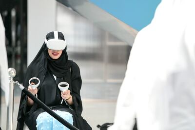 A visitor tests a VR headset at the Dubai Metaverse Assembly at the Museum of Future. Khushnum Bhandari / The National
