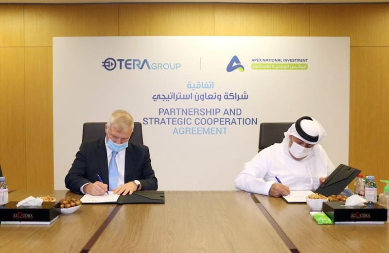 Representatives from Apex National Investment and TeraGroup sign the deal. WAM