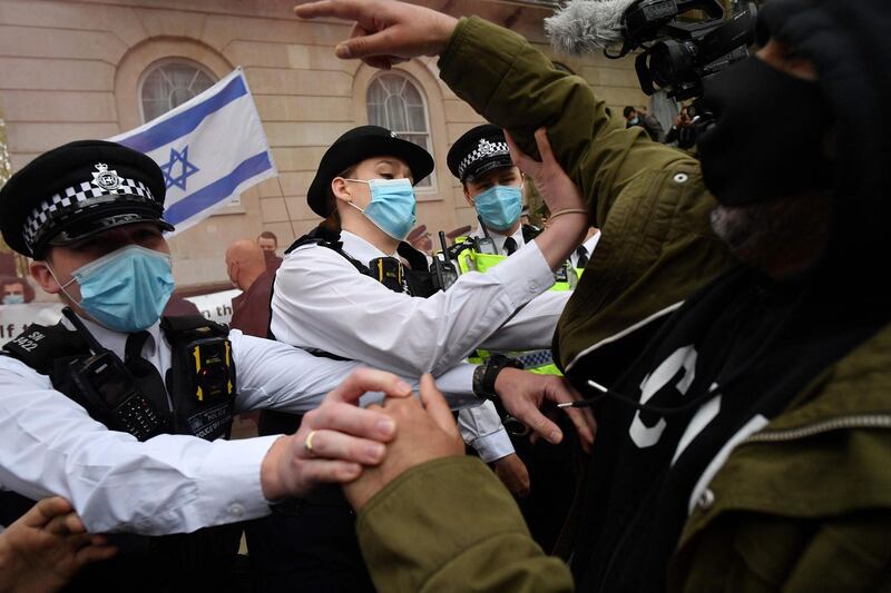 Police officers intervene between pro-Israel activists and pro-Palestinian activists participating in a demonstration protesting outside Downing Street. AFP