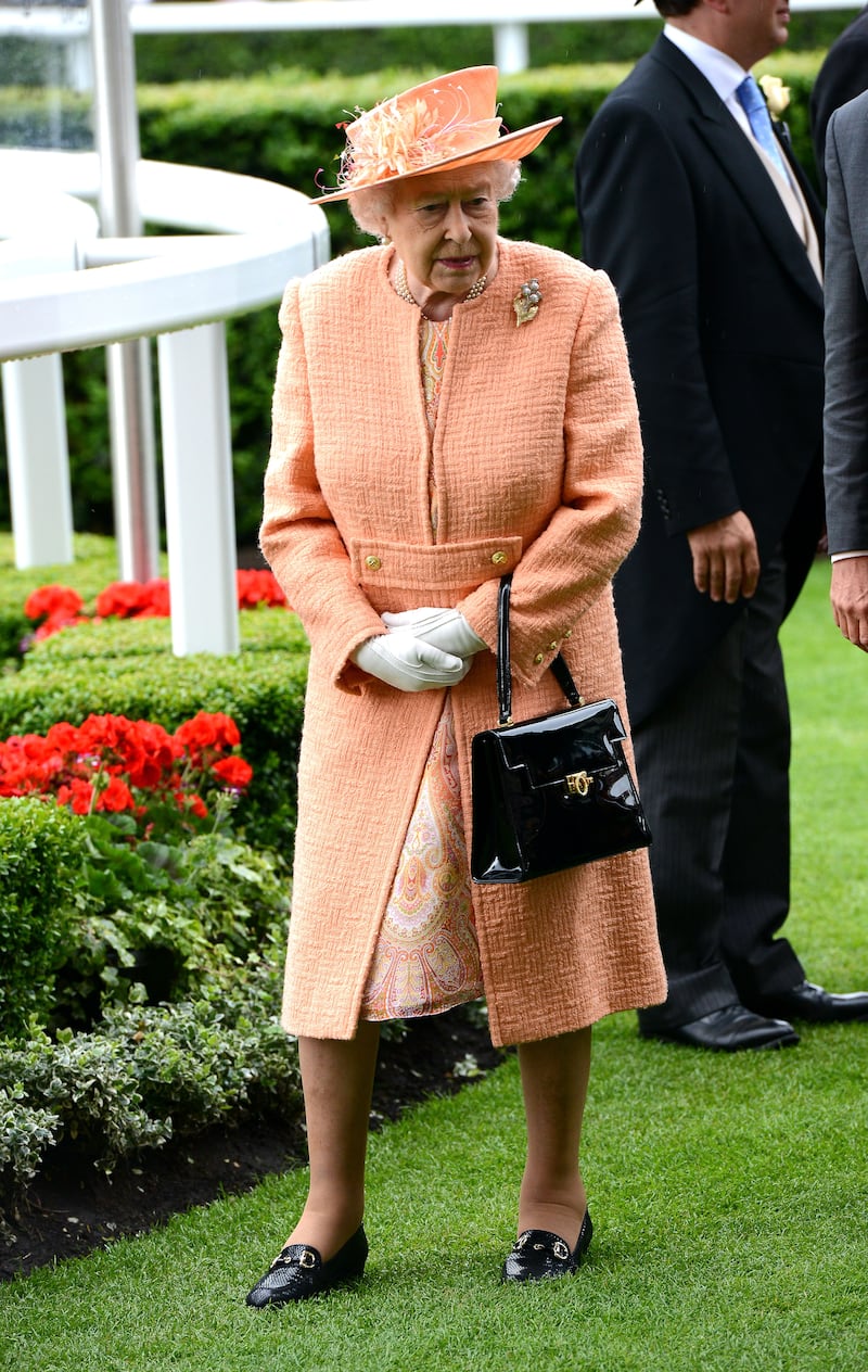 Queen Elizabeth II, wearing orange, attends Royal Ascot on June 20, 2015, in Berkshire, England. Getty Images