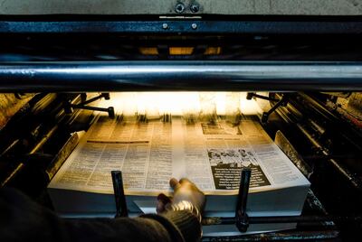 A technician retrives a freshly-printed page of the Afrika Gazetesi newspaper's forthcoming edition from the printing press, at its printhouse in the northern side of the Cypriot capital Nicosia in the self-proclaimed Turkish Republic of Northern Cyprus (TRNC), on December 13, 2018. Jail time and angry mobs -- editor Sener Levent has paid a price for challenging the might of Turkey's President Recep Tayyip Erdogan and local authorities in breakaway northern Cyprus with his newspaper. In January, hundreds of protesters attacked the offices of the newspaper -- a tiny daily with a 1,500 circulation in a statelet of around 300,000 people -- after it ran an article criticising a Turkish military offensive against the Kurdish border enclave of Afrin in Syria. / AFP / Amir MAKAR
